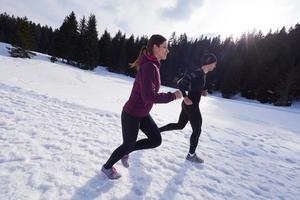 paar jogging buiten Aan sneeuw foto