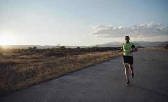 triatlonatleet die op ochtendtraining loopt foto