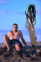 portret van een jong kitsurfen Mens Bij strand Aan zonsondergang foto