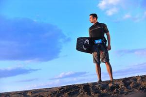 portret van een jong kitsurfen Mens Bij strand Aan zonsondergang foto