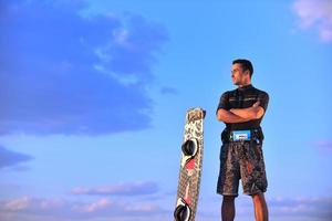 portret van een jong kitsurfen Mens Bij strand Aan zonsondergang foto