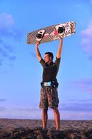 portret van een jong kitsurfen Mens Bij strand Aan zonsondergang foto