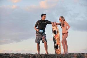 surfen paar poseren Bij strand Aan zonsondergang foto