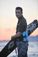 portret van een jong kitsurfen Mens Bij strand Aan zonsondergang foto