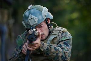 soldaat in actie het richten Aan wapen laser zicht optiek foto