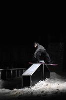 vrije stijl snowboarder springen in lucht Bij nacht foto