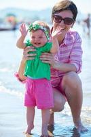 mama en baby op het strand veel plezier foto