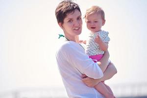 mama en baby op het strand veel plezier foto