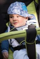 baby jongen zittend in de kinderwagen foto