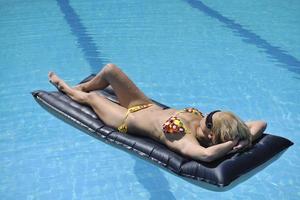 mooi vrouw kom tot rust Aan zwemmen zwembad foto