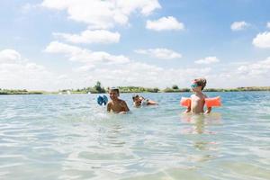 gelukkig familie spelen in water Aan zomer vakantie. foto