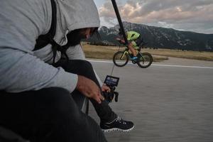 cameraman die actiefoto maakt van triatlonfietsatleet foto