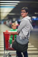 moeder met baby in boodschappen doen foto