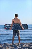 portret van een jong kitsurfen Mens Bij strand Aan zonsondergang foto