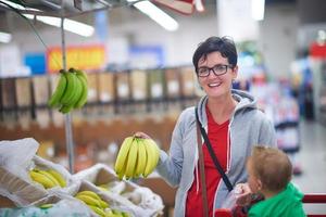 moeder met baby in boodschappen doen foto