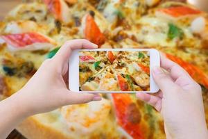 vrouw nemen foto van pizza en met mobiel smartphone