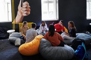 studenten gebruik makend van modern technologie voor school- project foto