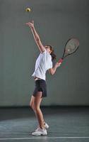 een jong vrouw Speel tennis foto