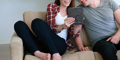 jong paar gebruik makend van digitaal tablet Bij huis foto