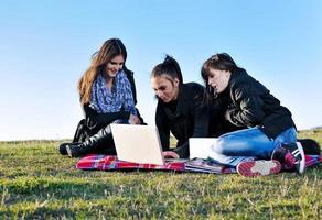 groep van tieners werken Aan laptop buitenshuis foto