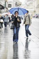 vrouw Aan straat met paraplu foto