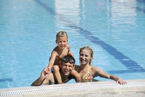 gelukkig jong familie hebben pret Aan zwemmen zwembad foto