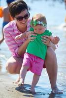 mama en baby op het strand veel plezier foto