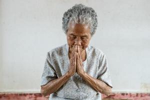bidden van senior Aziatisch vrouw foto