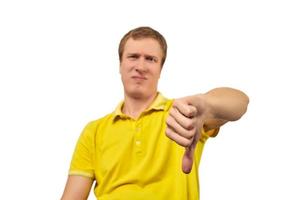 ongelukkige geërgerde man in geel t-shirt met duim omlaag gebaar geïsoleerd op een witte achtergrond foto