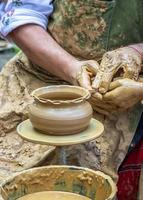 een meester van pottenbakkerij vakmanschap geeft les een kind wie wil naar leren hoe naar beeldhouwen een kruik. pottenbakkerij meester klas. foto