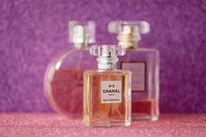 ternopil, Oekraïne - september 2, 2022 chanel aantal 5 eau première wereldwijd beroemd Frans parfum fles tussen andere parfums Aan glimmend schitteren achtergrond in Purper kleuren foto