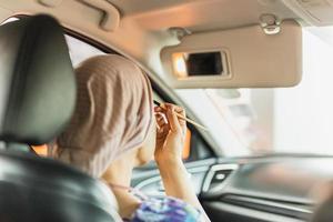 vrouw genieten terwijl bedenken haarzelf in de auto. foto