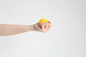 hand- drukken geel squishy bal voor oefening spier of voor gevoel kom tot rust van spanning in concept van Gezondheid zorg en medisch. foto