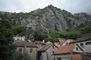 daken van huizen en hoog bergen in kotor, Montenegro foto