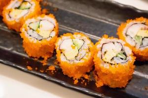 californië maki sushi roll op zwarte plaat, Japans eten foto
