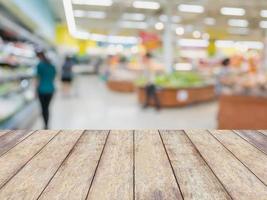 leeg hout tafel met vervagen kruidenier op te slaan achtergrond foto