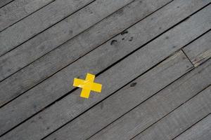 geel kruis markering plakband Aan de hout bord verdieping van top visie het schieten Bij buitenshuis veld- voor achtergrond of backdrop foto