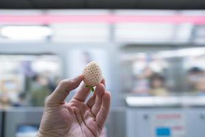 wit aardbei type, maar zoet en heerlijk was gehouden in de hand- met de metro ondergronds achtergrond. foto