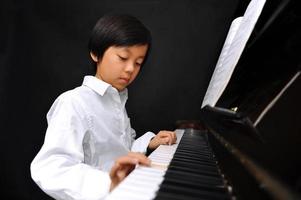 jonge Aziatische jongen piano spelen