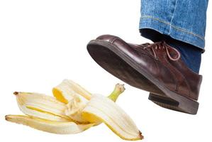 links voet in jeans en schoen uitglijden Aan banaan Pel foto