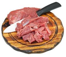 besnoeiing rauw vlees en keramisch mes Aan snijdend bord foto