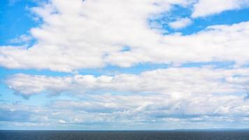 wit wolken in blauw lucht over- kalmte Baltisch zee foto