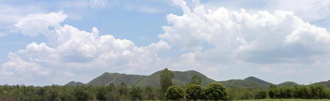 blauw lucht met bomen, wolken en bergen, lucht achtergrond afbeelding, panorama visie foto