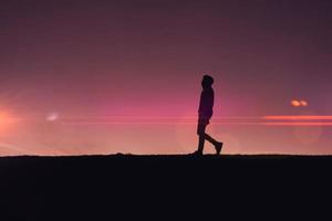 Mens trekking in de platteland met een mooi zonsondergang achtergrond foto