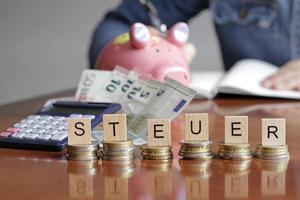 brieven Aan stapels van munten spelling steuer - Duitse voor belastingen foto