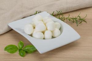 Mozzarella kaas in een kom Aan houten achtergrond foto