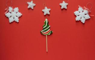 snoep riet in de het formulier van een Kerstmis boom Aan een rood achtergrond.kerstmis decoraties in de omgeving van een lolly. vrolijk Kerstmis gelukkig nieuw jaar foto