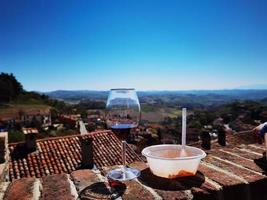 glas van wijn en bord van ravioli met een visie van de piemontese langhe van monforte d'alba foto