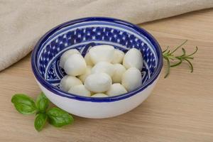 Mozzarella kaas in een kom Aan houten achtergrond foto