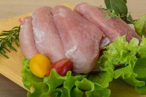 rauw varkensvlees schnitzel Aan houten bord en houten achtergrond foto